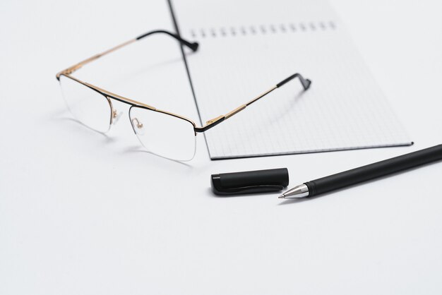 Opened notebook with pen and glasses isolated