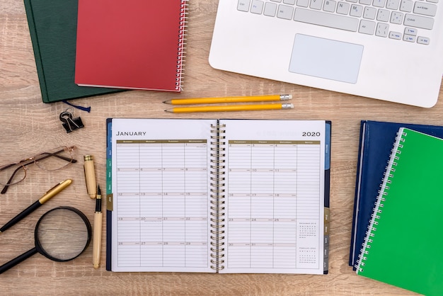 Opened notepad with laptop on wooden table