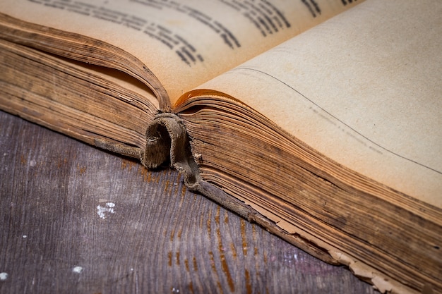Открытая старая книга на деревянном столе