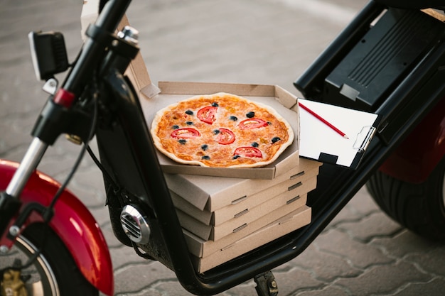 Scatola per pizza aperta sulla consegna moto