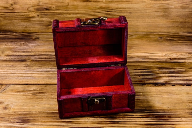 Photo opened vintage chest from red wood on wooden background