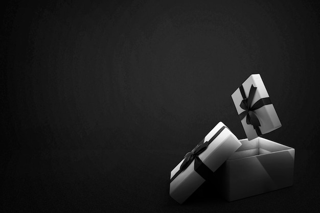 Opened a white gift box with a black ribbon with a black background. Black Friday concept