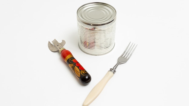 Opener with wooden handle, fork and shiny metal tin isolated on white background