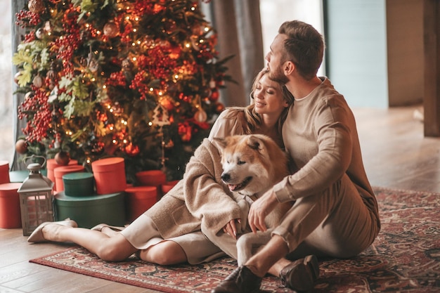 Openhartig authentiek gelukkig getrouwd stel brengt tijd door met japanse hond in xmas lodge