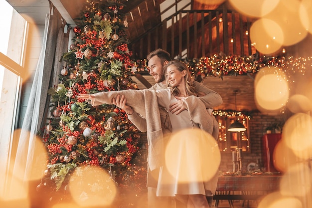 Openhartig authentiek gelukkig getrouwd stel dat samen tijd doorbrengt in een houten lodge met kerstversiering