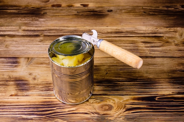 Opening of the aluminium tin can with chopped canned pineapple