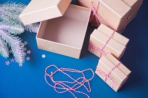 Opening and empty Christmas gift boxes on the blue background with pine branch and Christmas decoration