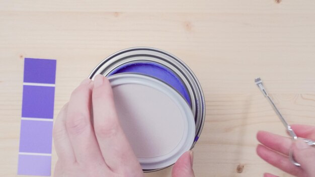 Opening metal paint can with purple interior paint.