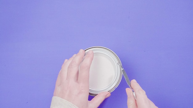 Opening metal paint can with violet interior paint.