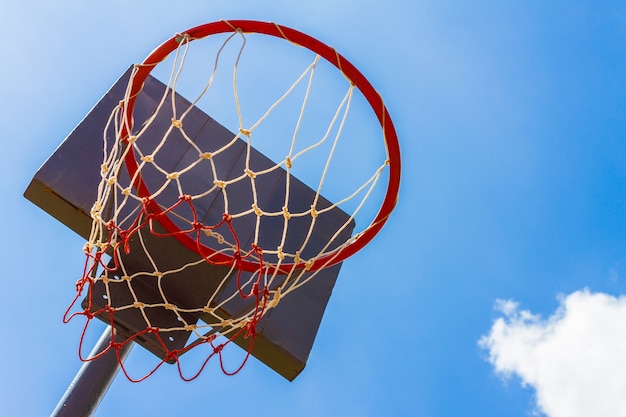 Openlucht basketbalhoepel met blauwe hemel en wolkenachtergrond