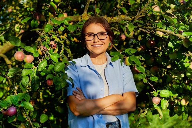 Openluchtportret van een vrouw van middelbare leeftijd in een appelboomgaard