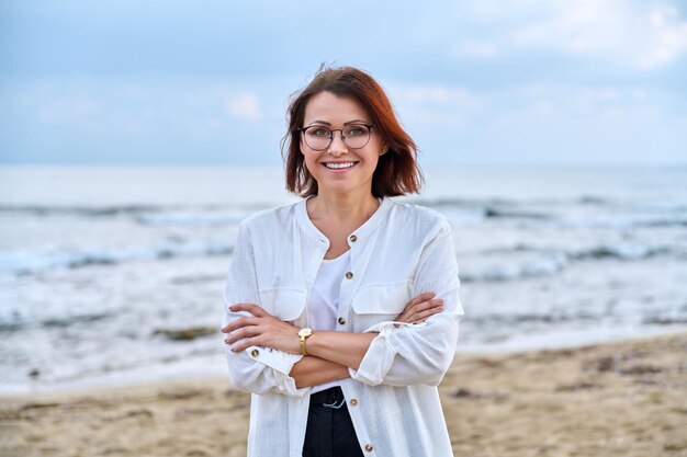 Openluchtportret van succesvolle vrouw van middelbare leeftijd met gevouwen handen