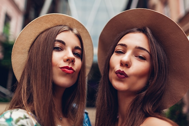 Openluchtportret van twee jonge mooie modieuze vrouwen die selfie nemen. meisjes met plezier in de stad. beste vrienden