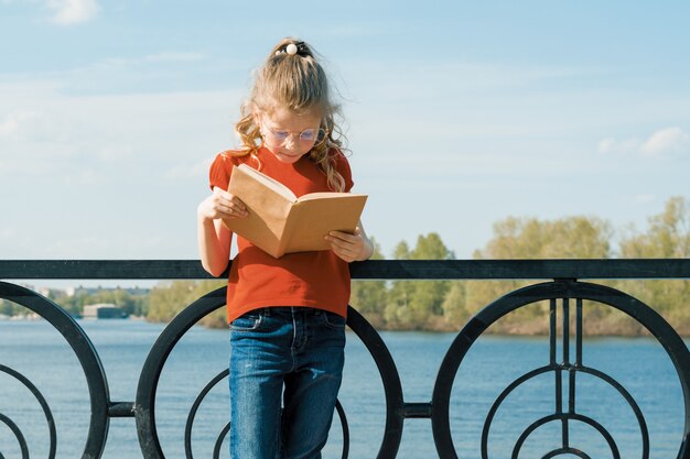 Openluchtportret van weinig schoolmeisje met boek, meisjeskind