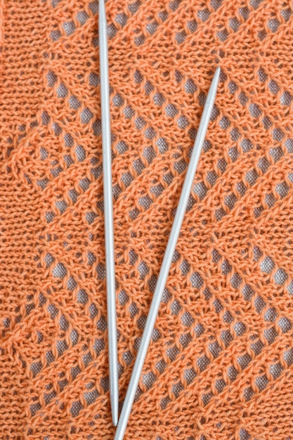 Ажурный узор оранжевой нитью и парными спицами