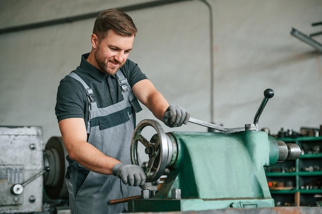 Operating manufacturing equipment man in uniform is in\
workstation developing details of agriculture technique