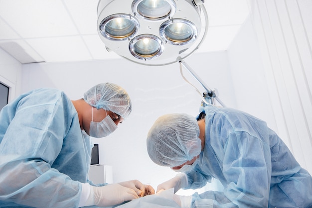 Фото Операция в современной операционной крупным планом, экстренное спасение и реанимация больного. медицина и хирургия.
