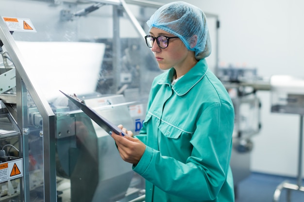 The operator controls the machine in the factory work