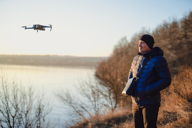 Operator kijkt naar zijn quadrocopter Man fotograaf met dron Aeromodelling hobby vrijetijdsconcept Taille omhoog