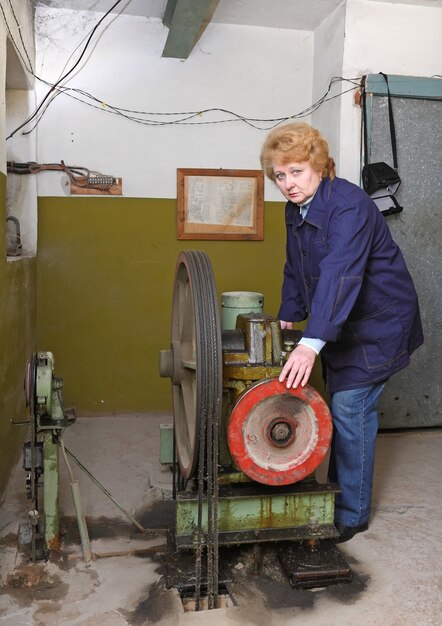 Operator vrouw-ingenieur in machinekamer (lift) controleer de mechanische uitrusting.