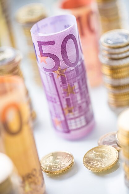 Foto opgerolde eurobankbiljetten en munten torens gestapeld in andere posities.
