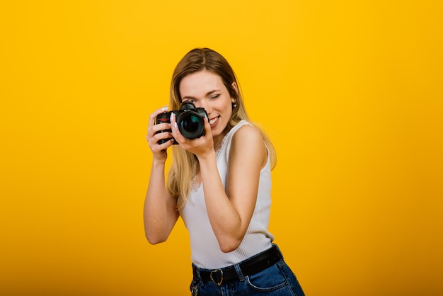 Opgewekte vrouwelijke fotograaf die in studio werkt.