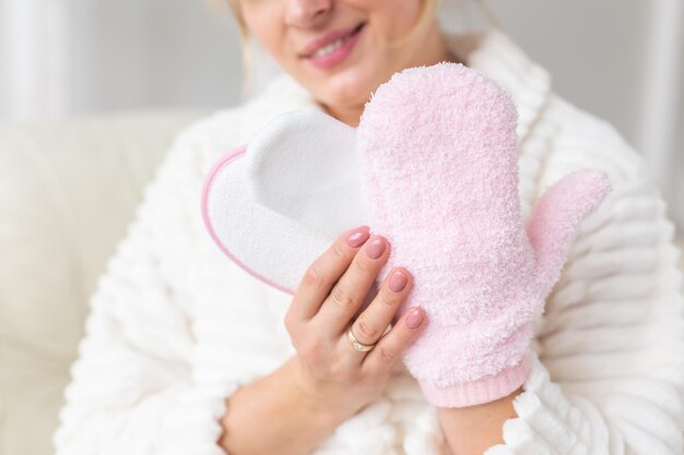 Opgewonden blije jonge vrouw gewikkeld hoofd in handdoek met droge borstel douchespons en kuuroordprocedure doen