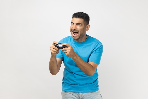 Opgewonden extreem gelukkige man gamer die videogames speelt met joystick in handen