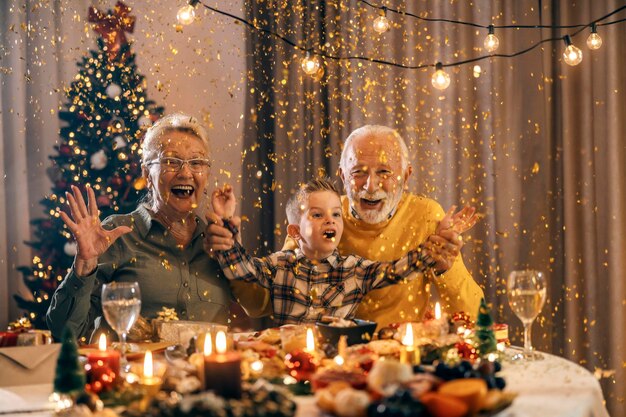 Opgewonden grootouders vieren kerstmis en oudejaarsavond thuis met hun kleinzoon.