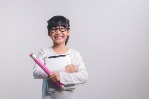 Opgewonden jong meisje dat grote potloden in haar handen houdt Terug naar school