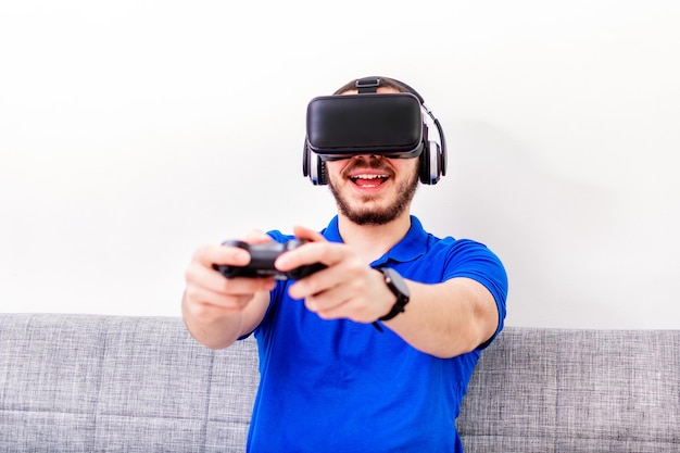 Opgewonden jonge hipster-man die thuis alleen een videogame speelt virtual reality 3d futuristisch spelsimulator-ervaringsconcept