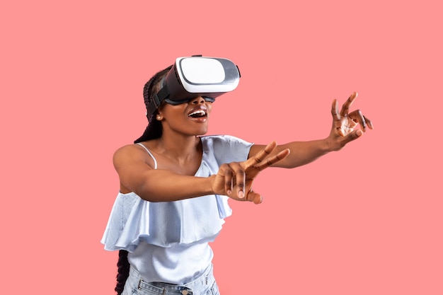 Opgewonden jonge zwarte dame in vr-bril in interactie met cyberspace die online game speelt in virtueel