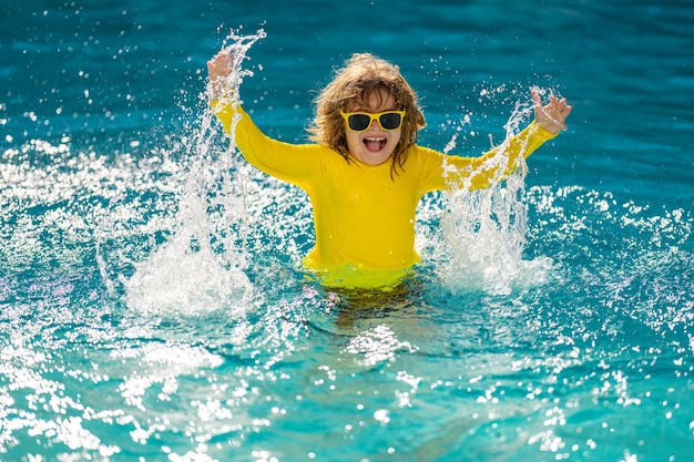 Opgewonden kind dat een klein kind zwemt dat in het blauwe water van het zwembad speelt in een tropisch resort in