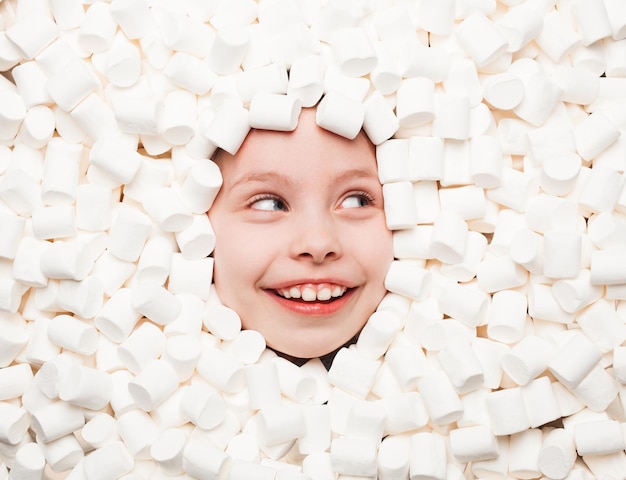 Opgewonden kind poseren in zoete marshmallows