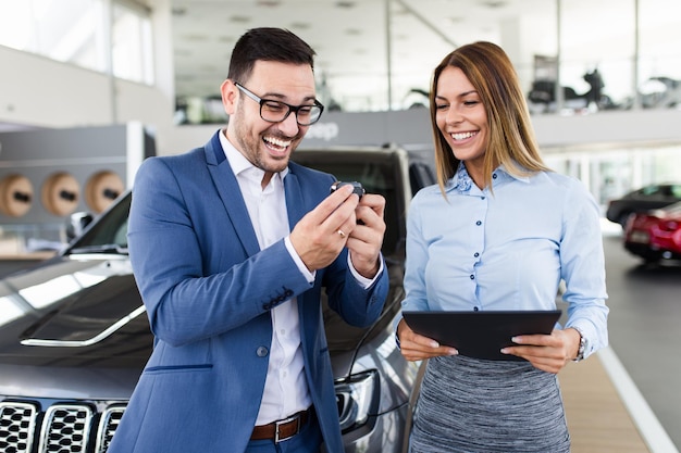 Opgewonden man blij vanwege het kopen van een nieuwe auto.