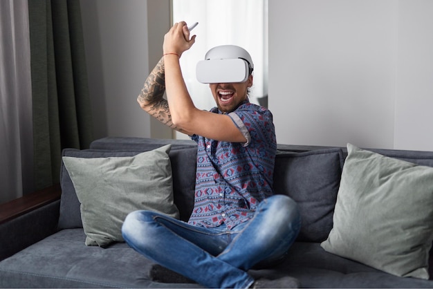 Opgewonden man die thuis actie VR-game speelt