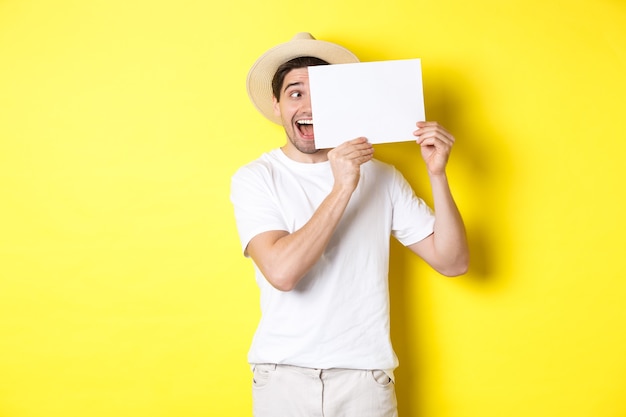 Opgewonden man op vakantie met blanco vel papier voor uw logo, met bord in de buurt van gezicht en