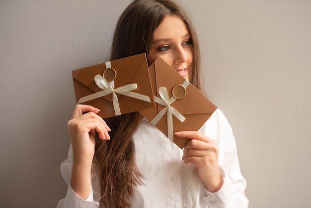 Opgewonden meisje neemt graag bronzen envelop met cadeaubon of voucher