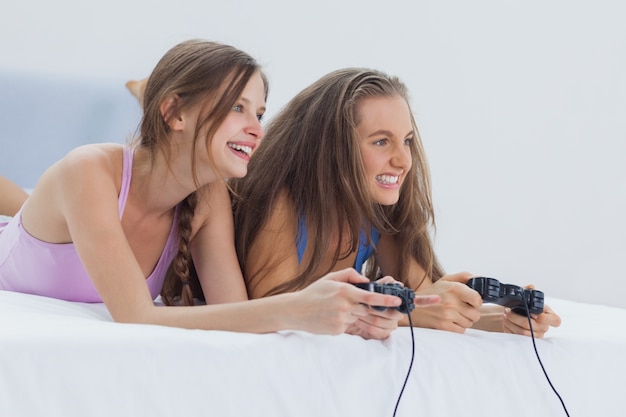 Foto opgewonden meisjes spelen van videogames op bed