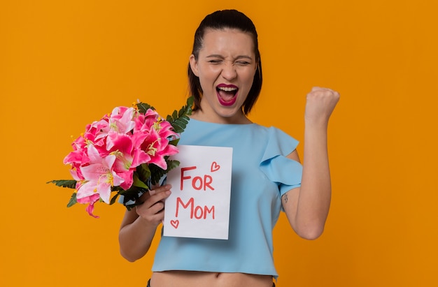 Opgewonden mooie jonge vrouw met boeket bloemen en brief van haar kind