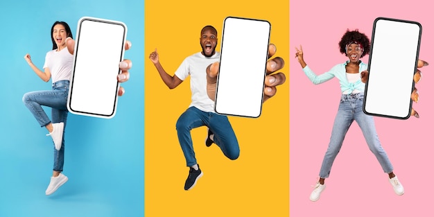 Opgewonden multinationale millennials springen met mockup voor mobiele telefoons