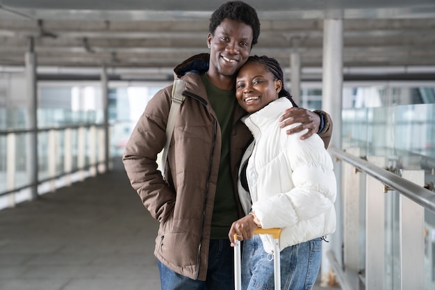Opgewonden paar reizen gelukkig afrikaanse toeristen glimlach verlaten luchthaven bij aankomst naar vakantiebestemming