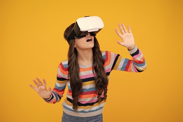 Opgewonden tiener met Vr-headset Meisje speelt vr-videogame Digitale toekomst en innovatie Kind in virtuele bril Opgewonden tienermeisje met virtual reality-bril headset geïsoleerd op geel