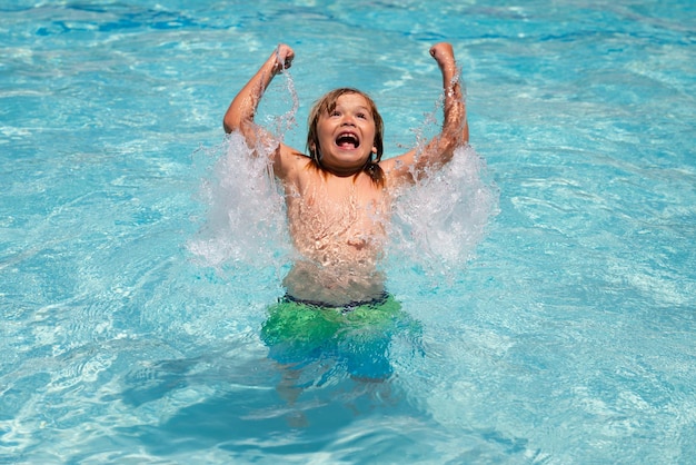Opgewonden verbaasd kind spetteren in zwembad klein kind jongen in zwembad zwemmen op zomervakantie