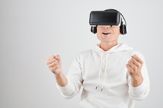 Opgewonden volwassen man in virtual reality-bril winnend spel