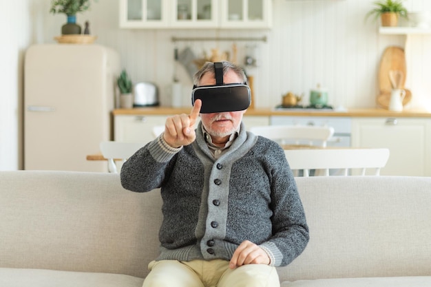 Opgewonden volwassen senior man met behulp van virtual reality metaverse vr bril headset thuis opa