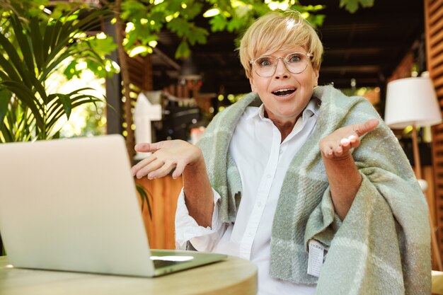 Opgewonden volwassen vrouw gewikkeld in een deken