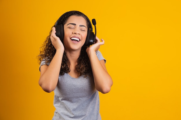 Opgewonden vrouw luisteren naar muziek op koptelefoon.