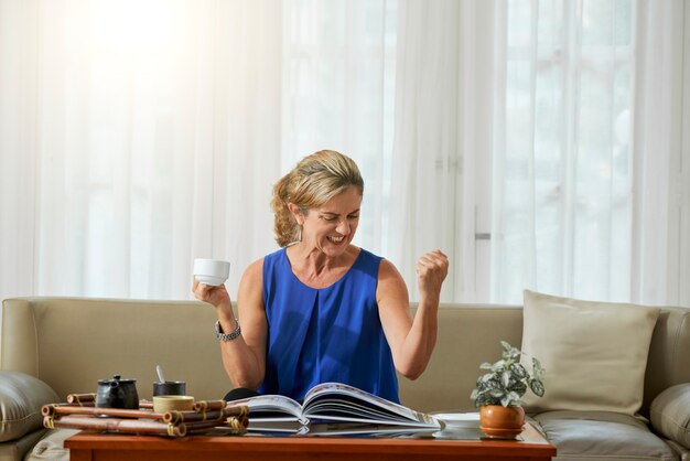 Opgewonden vrouw zitten in de woonkamer