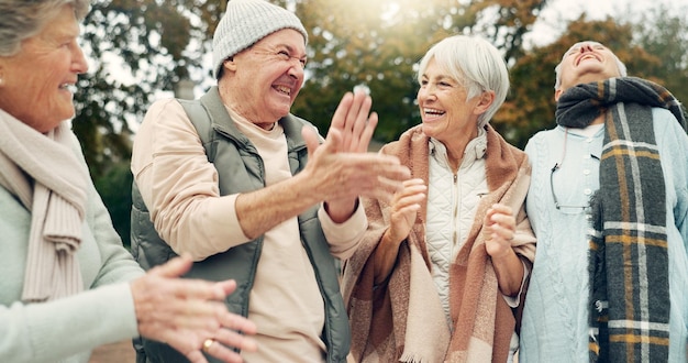 Foto opgewonden zingen en oudere mensen in de natuur voor kamperen geluk en banden samen glimlach dans en gezicht portret van oudere vrienden man en vrouw die plezier hebben met een viering in een park